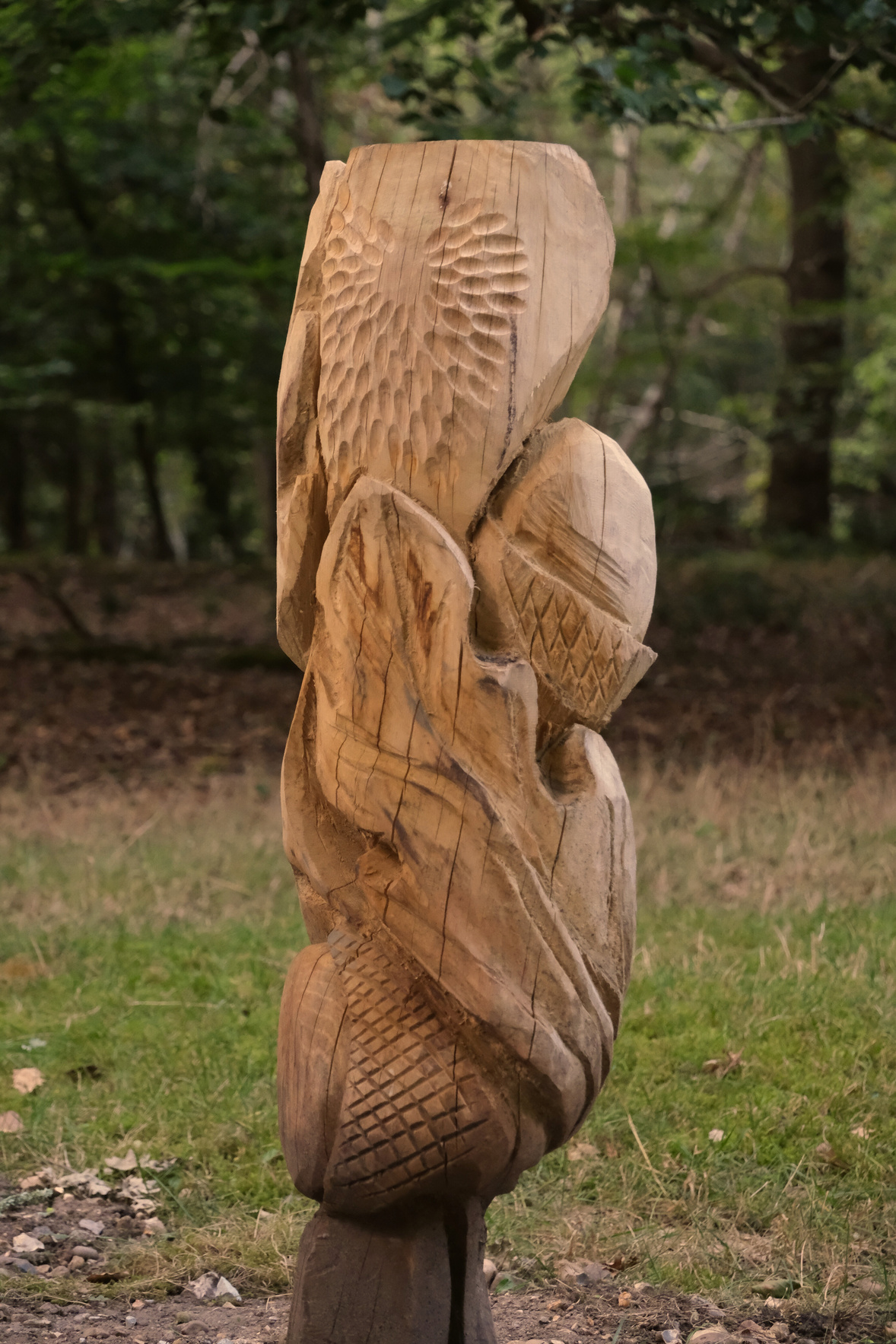 a carved wooden sculpture on an Oak leaf and acorn in the woods